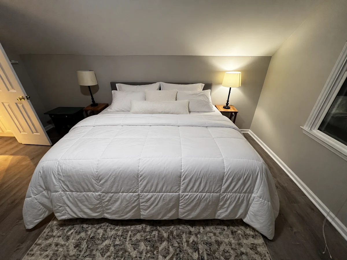 The same bedroom with neatly arranged bedding.