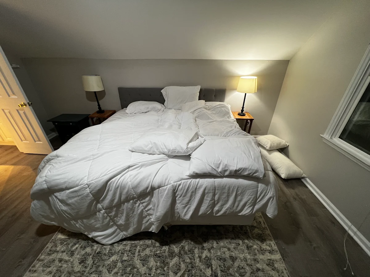 A bedroom with rumpled bedding.